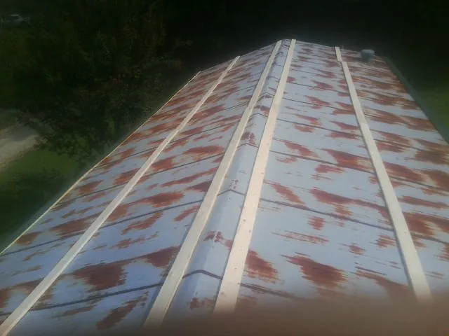 Rusted metal roof panels with new wood purlins before replacement — Storm Damage Roof Repair in Arion by Roofing Brothers