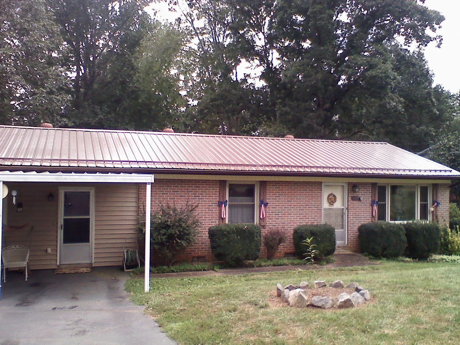 Bronze metal roof and carport on a brick ranch home — Roof Repair work by our crew in Arion